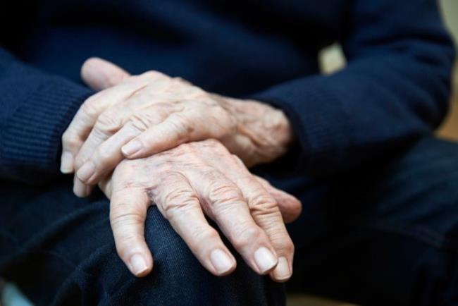 אדם מבוגר אוחז בידו הרועדת, פרמיפקסול לטיפול בפרקינסון
